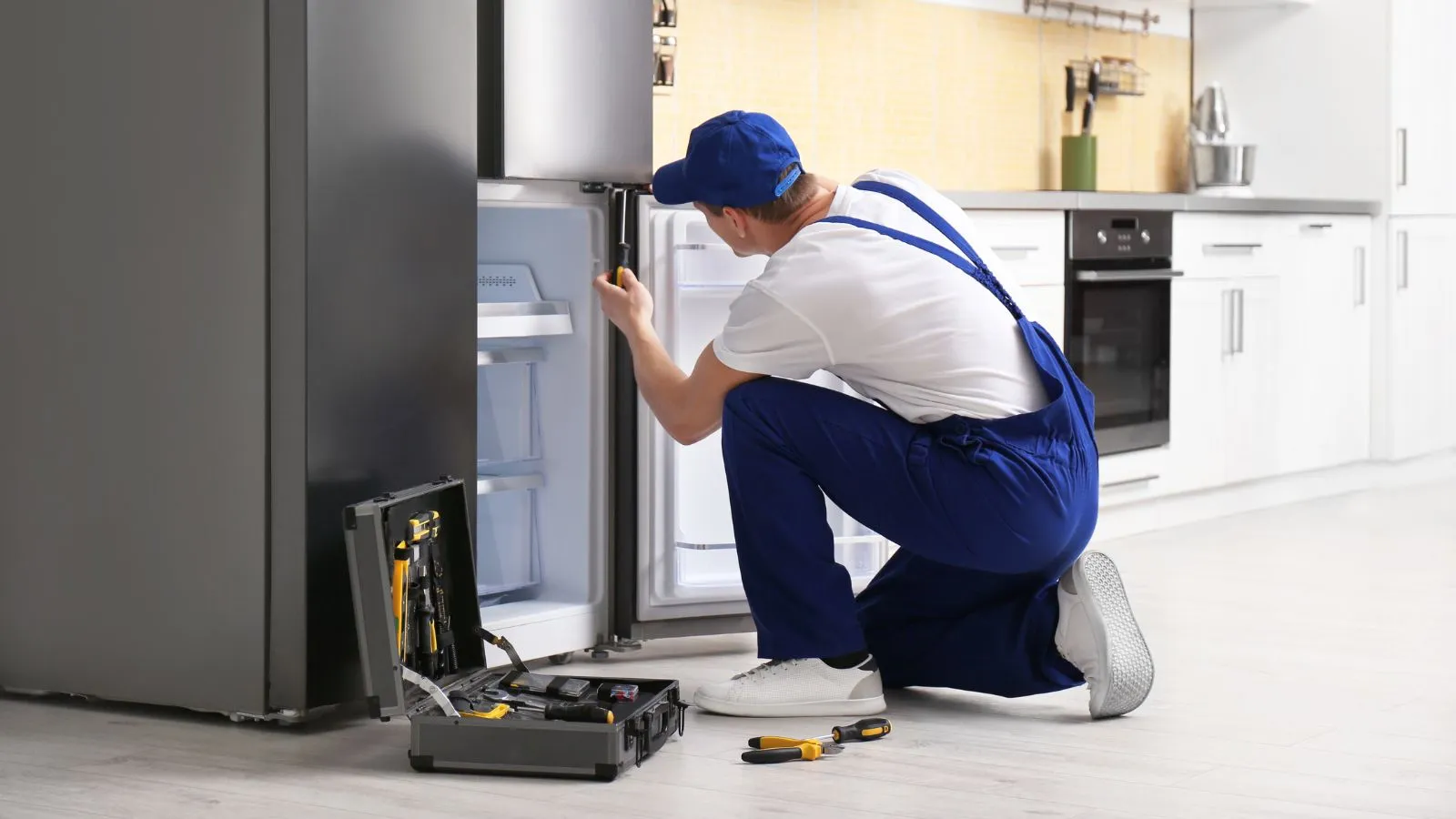 Appliance repair technician fixing a Fridge