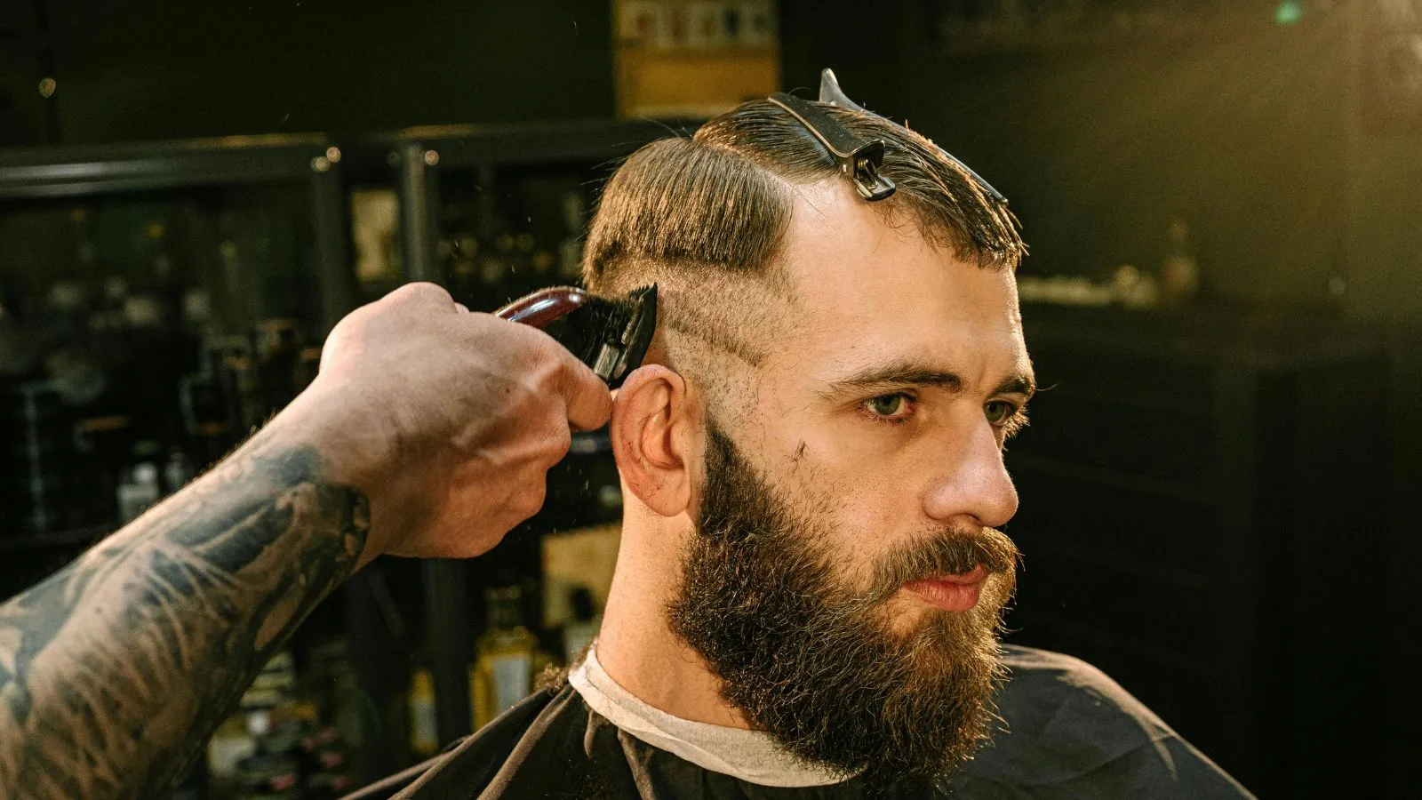 Barber giving a client a fresh fade and beard trim in a modern shop
