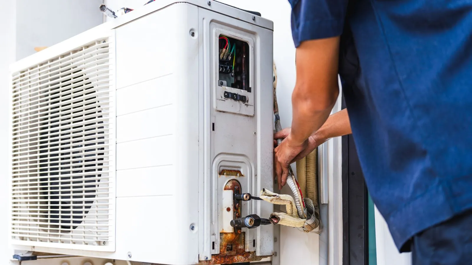 HVAC technician servicing an outdoor air conditioning unit